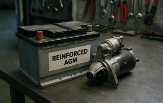a reinforced AGM battery and starter motor removed from a Jaguar engine bay lying on a workbench