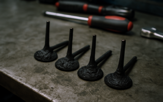 heavily carbon-fouled intake valves from an Audi RS4 4.2 FSI V8 engine laid out on a workbench