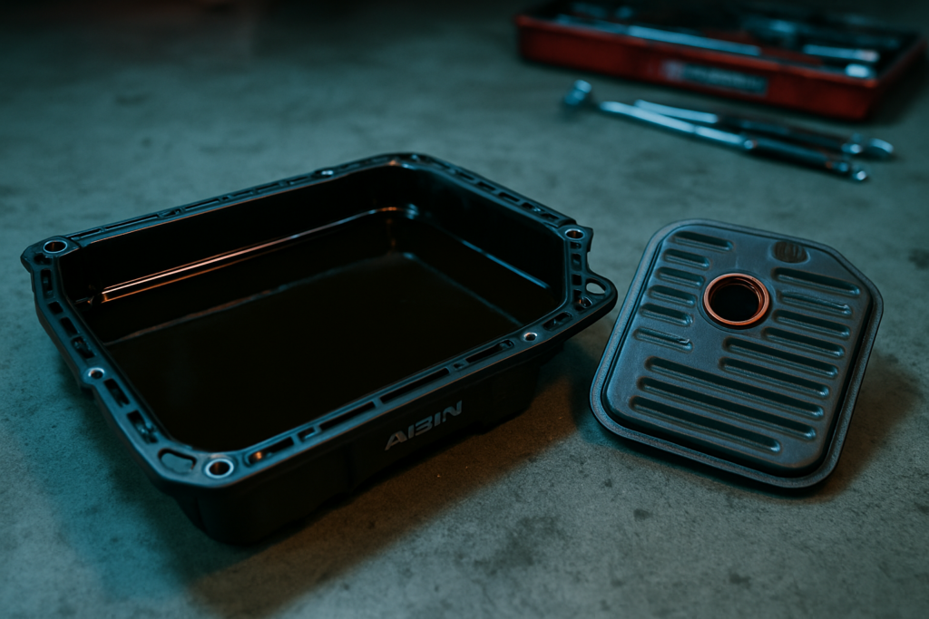 Aisin EAT8 automatic gearbox oil drain pan filled with dark degraded ATF fluid beside a used transmission filter